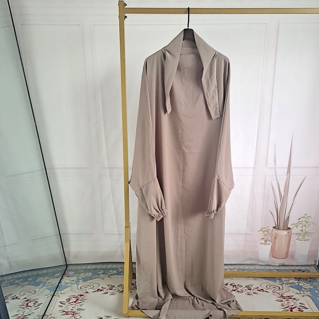 Abaya noire fluide femme avec hijab contrastant, coupe ample et élégante
