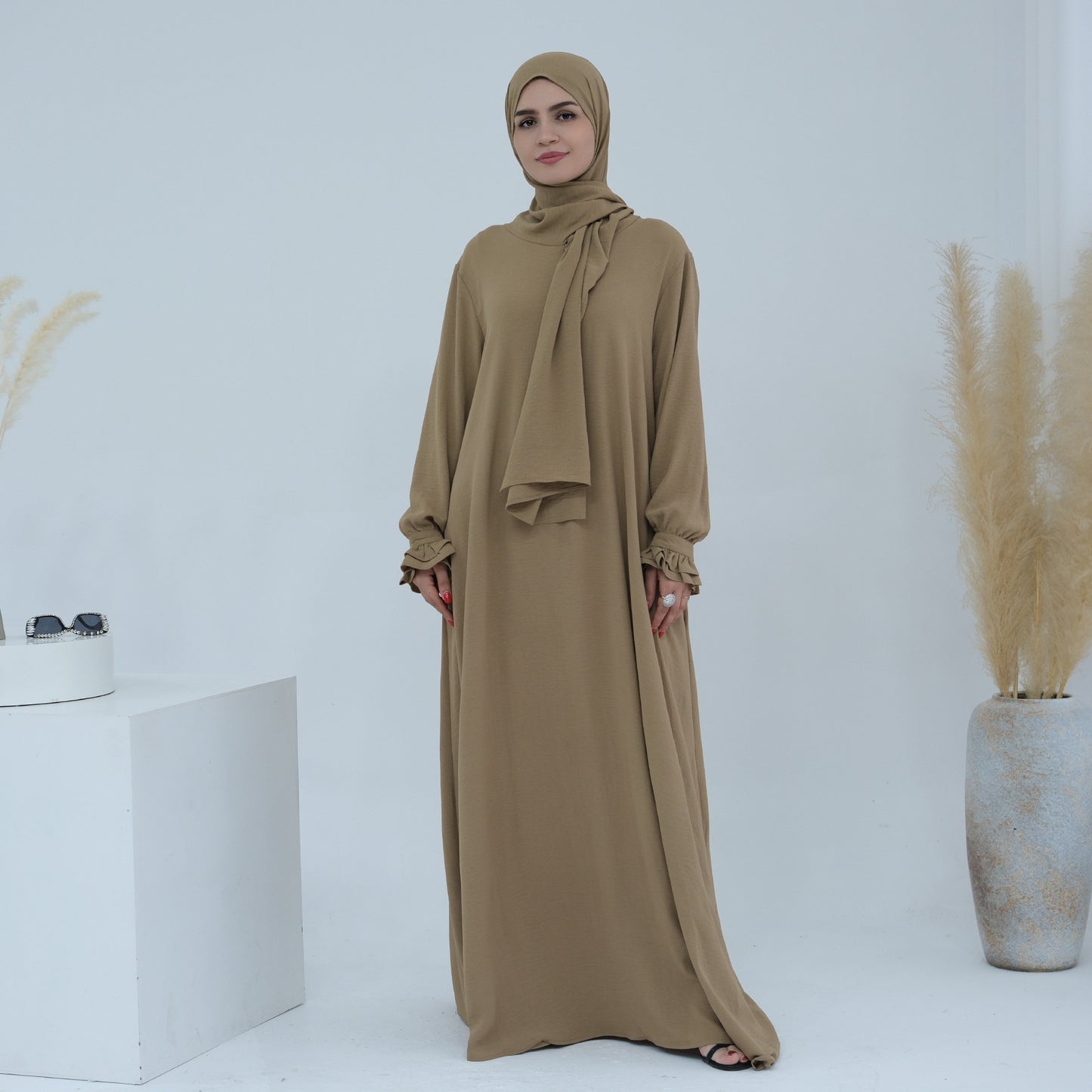 Douceur & élégance dans un style moderne. Découvrez cette abaya au design fluide et léger, sublimée par ses manches à volants délicates
